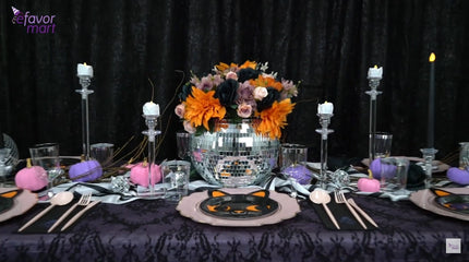 Final Halloween table setup with floral disco ball centerpiece, candles, and pink-and-purple pumpkins.