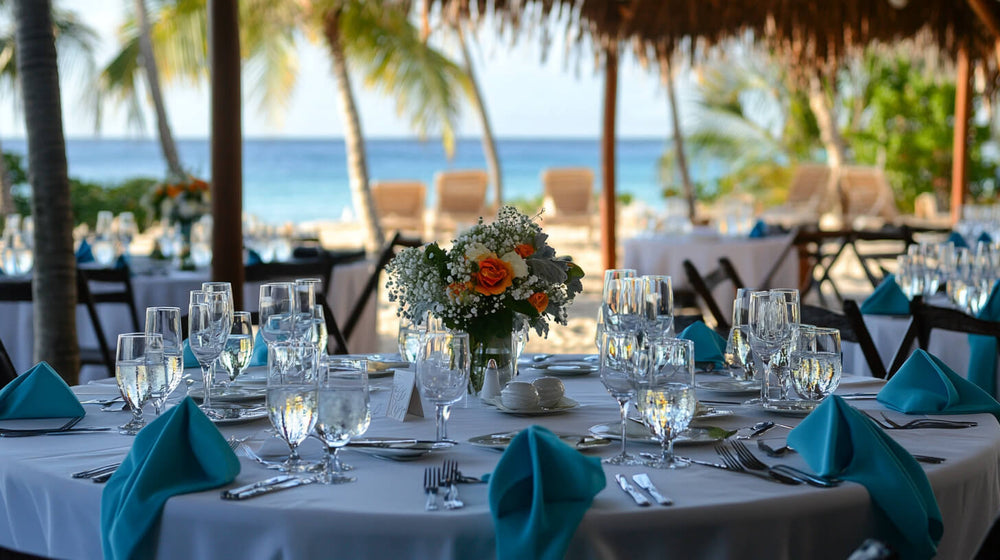 Elegant table setting with turquoise napkins and floral beach decor.