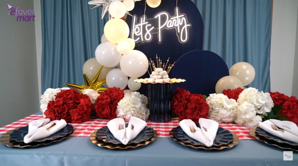 Elegant 4th of July table decor with 'Let's Party' neon sign, balloon garland, and red, white, and blue floral centerpiece.