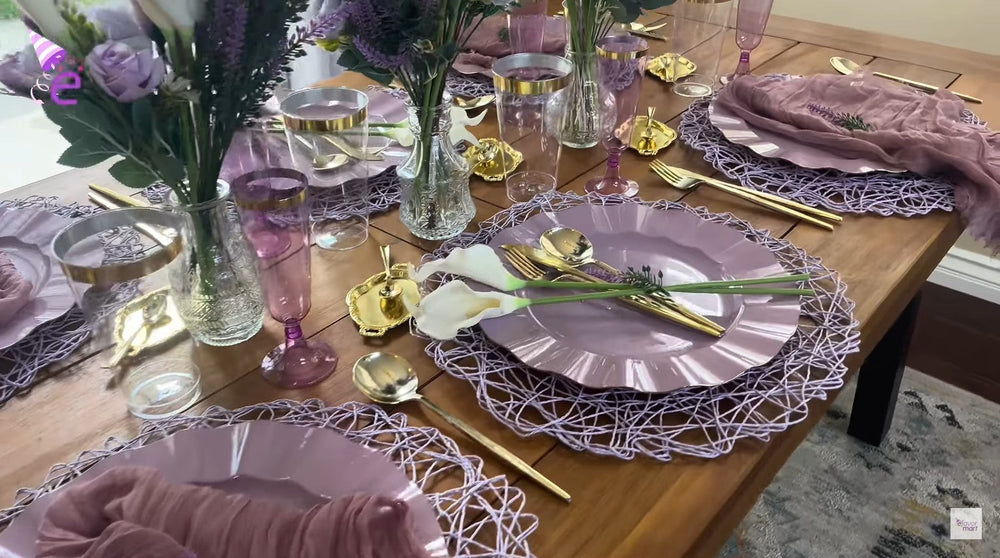 Lavender tablescape with gold flatware, purple plates, and floral centerpieces.