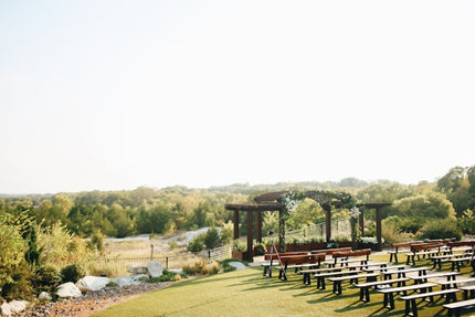 Outdoor countryside ceremony setup with benches for a destination wedding in nature.