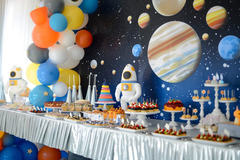 Space-themed party setup with planets, balloons, and a food table, perfect for theme birthday party ideas.