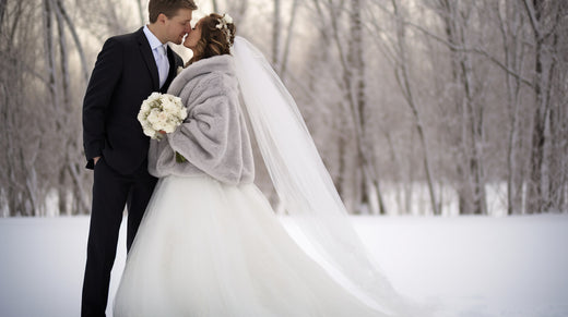 Romantic couple sharing a kiss in a snow-covered forest, perfectly showcasing winter wedding themes.