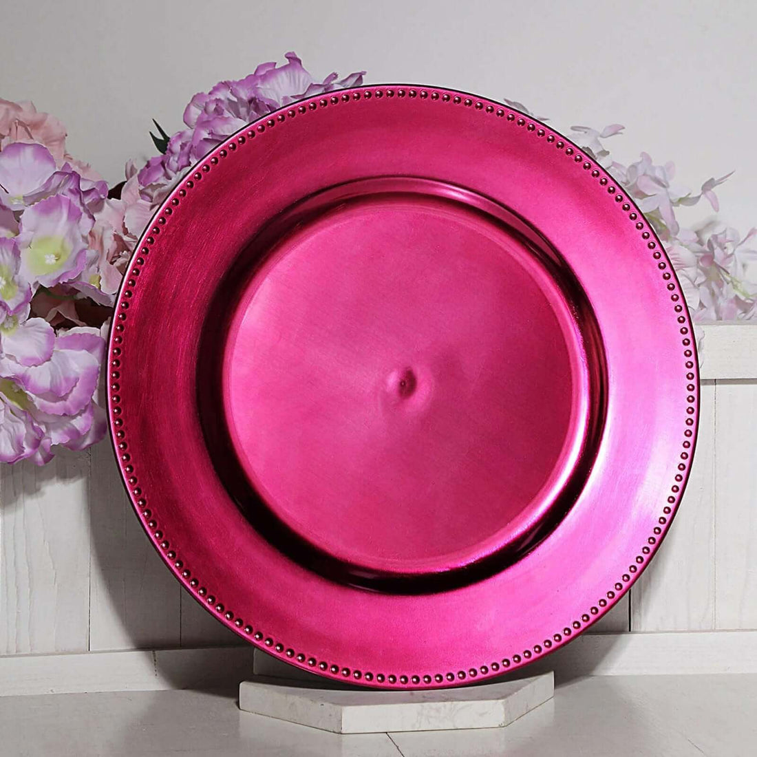 Acrylic hot pink round charger plates with a beaded rim design, measuring 13 inches and 9 inches