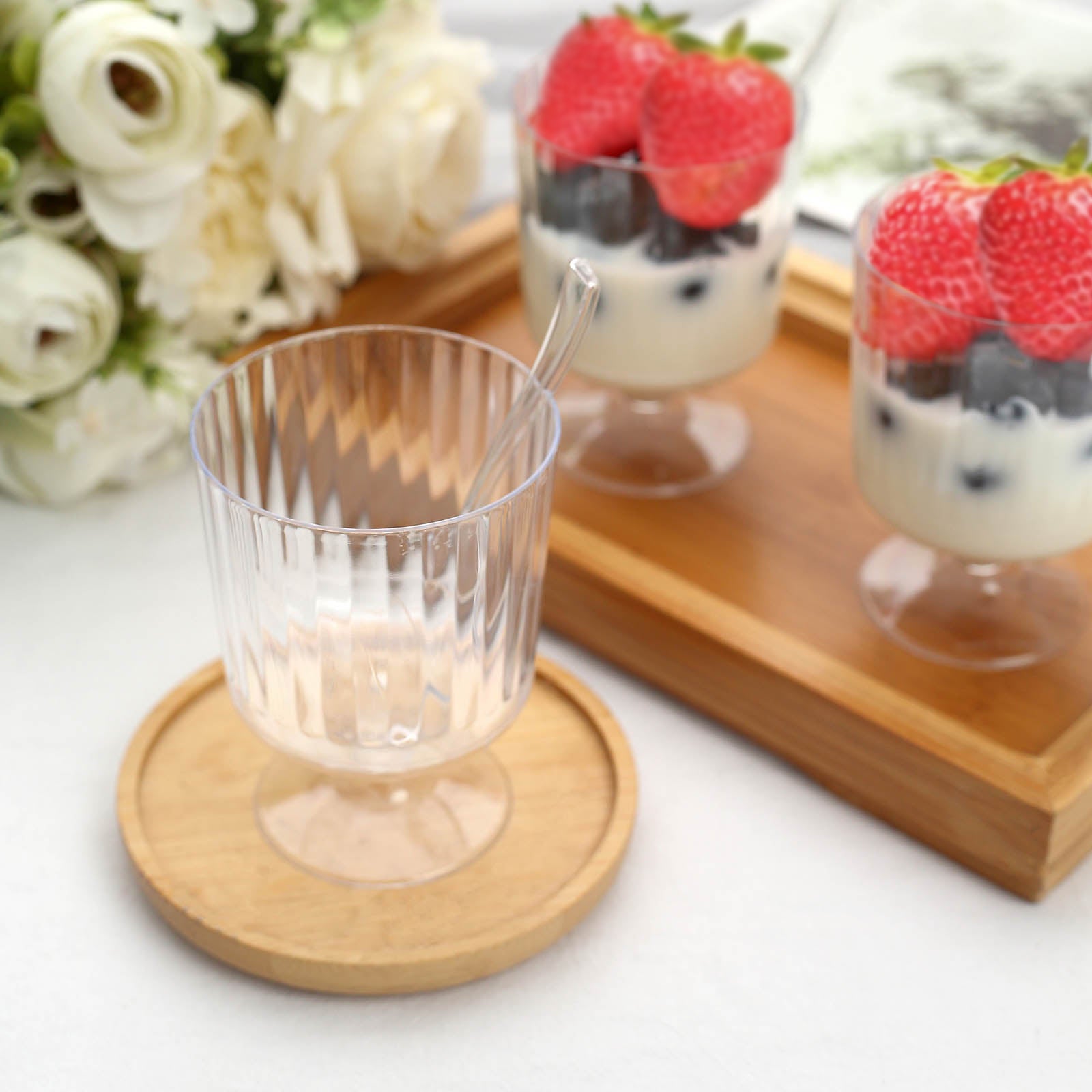https://www.efavormart.com/cdn/shop/products/Clear-Mini-Ribbed-Pedestal-Plastic-Dessert-Cups-With-Spoons.jpg?v=1689408344