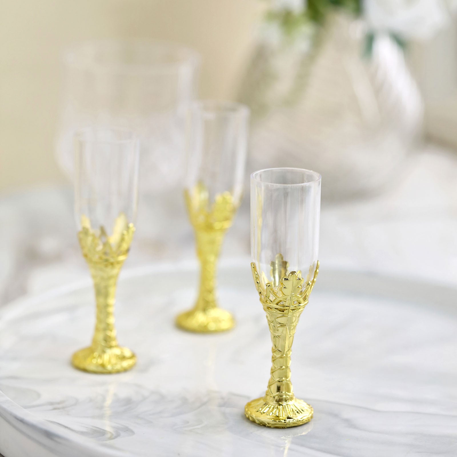 https://www.efavormart.com/cdn/shop/products/Gold-Stem-Clear-Plastic-Mini-Champagne-Flute-Glasses.jpg?v=1698179237